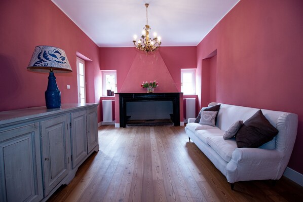 Una sala de estar con chimenea, un sofá blanco y una lámpara azul.