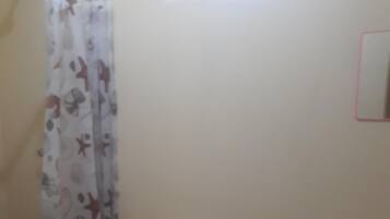 Een douche, handdoeken, zeep, toiletpapier