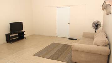 Habitación Deluxe | Área de sala de estar | Televisión de pantalla plana