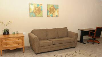 Habitación Deluxe | Área de sala de estar | Televisión de pantalla plana