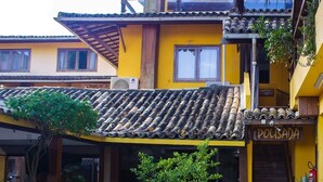 A yellow building with a tiled roof and a sign reading "POUSADA". - Pousada Funny (Cairu)