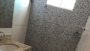 A bathroom with a toilet, sink, and shower area. - Pousada Porto Brasil (Pocoes)