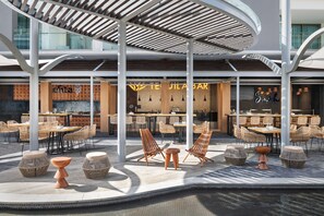 An outdoor seating area with wicker furniture and a pool.