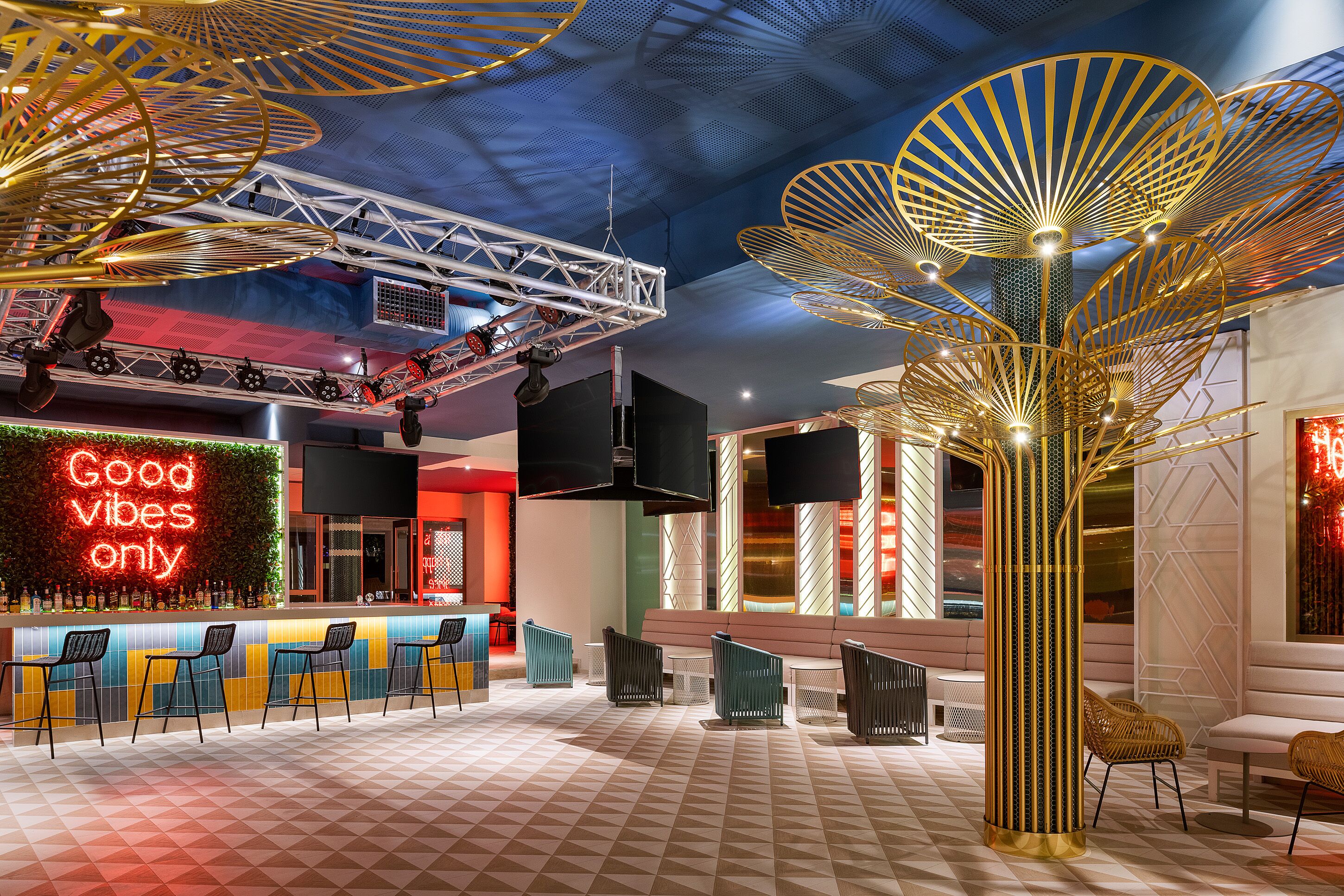 Et moderne barområde med neonskilte, siddepladser og unikke loftdesigns.