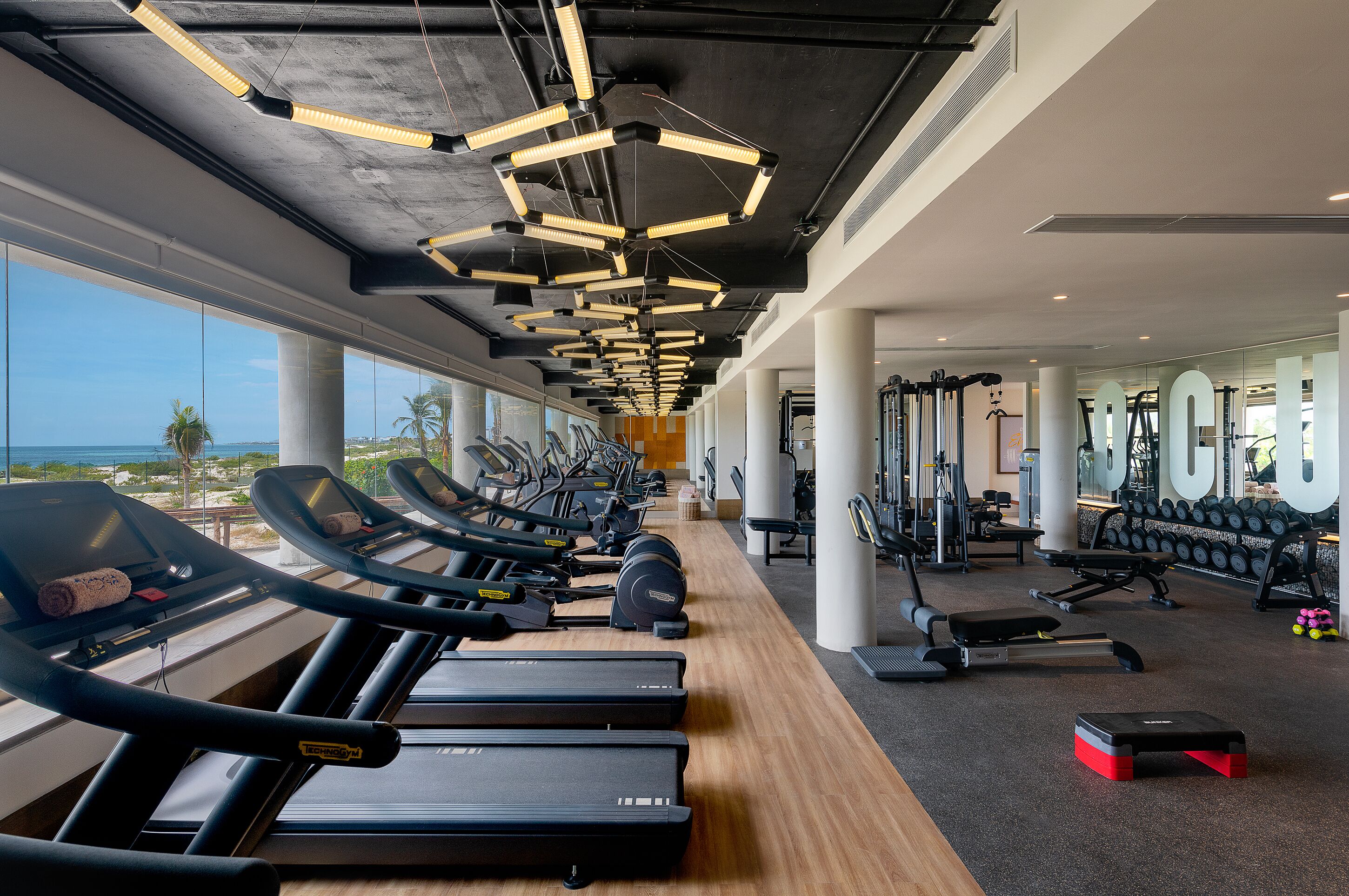 Ein Fitnessstudio mit Laufbändern, Gewichten und Trainingsgeräten.