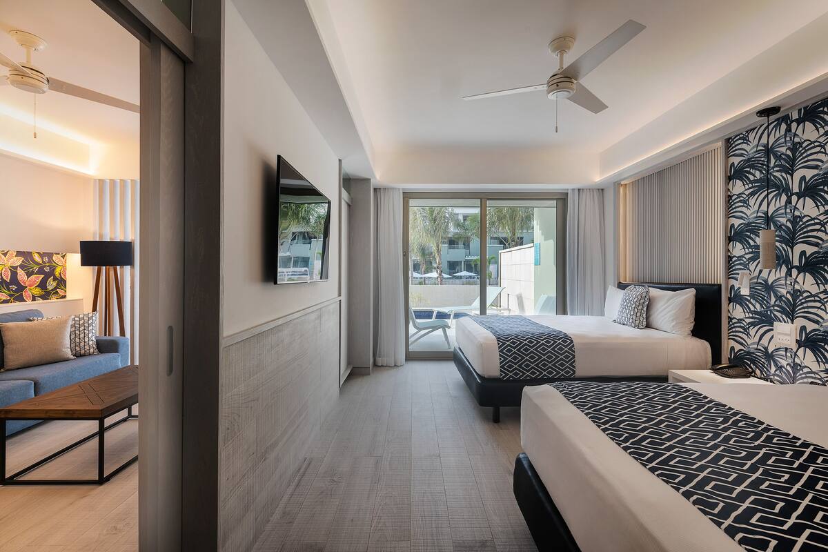 Ein Hotelzimmer mit Bett, Schreibtisch, Fernseher und Blick nach außen.