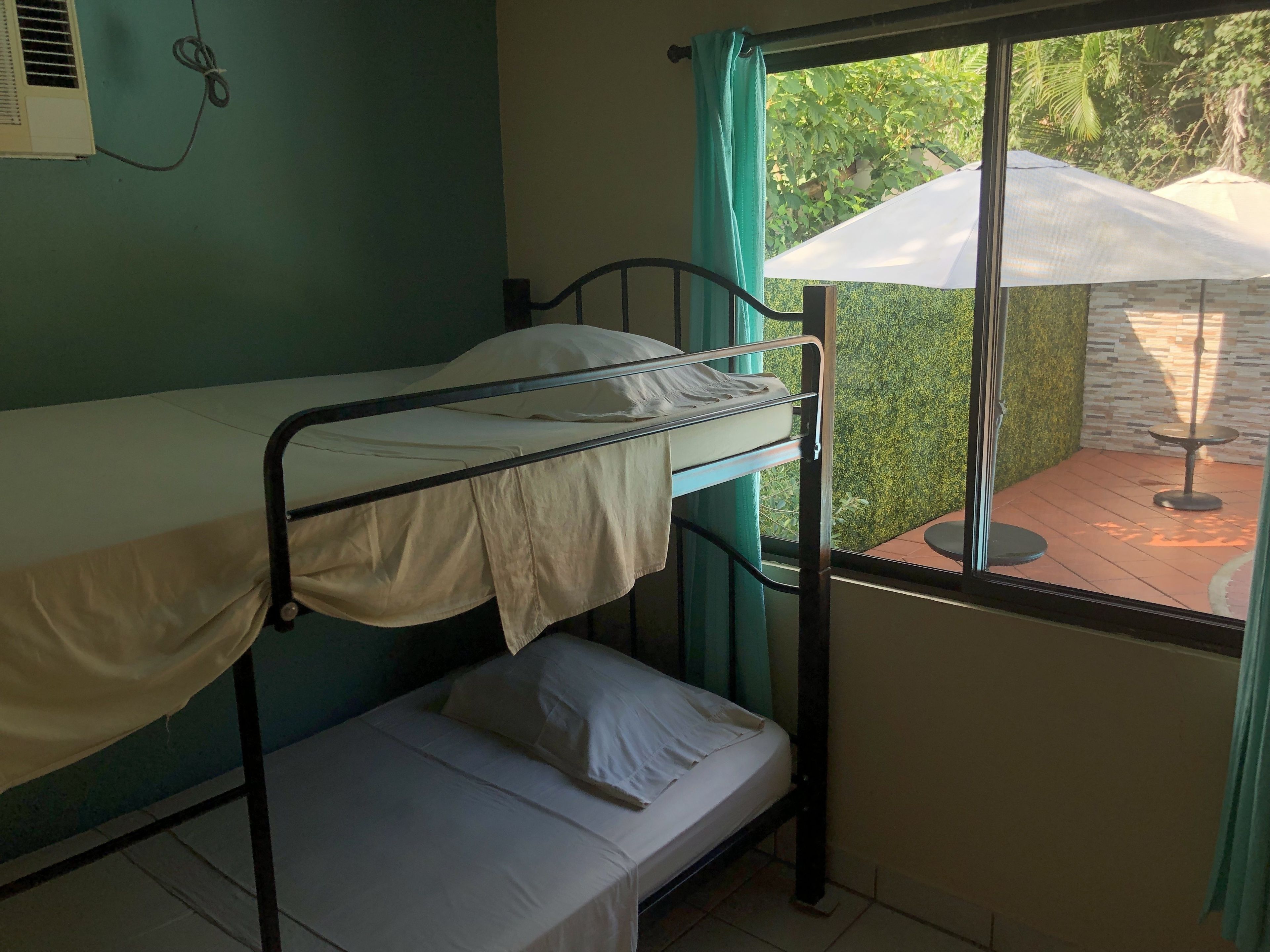 A bunk bed room with a window overlooking a garden.