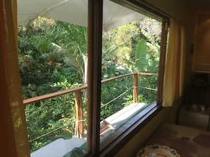 A room with a large window overlooking a lush garden.