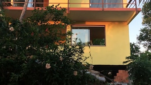 A modern two-story building with a balcony, large windows, and a visible door. - Pousada VillaBahia (Cairu)