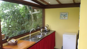 A kitchen with a stainless steel sink, a kettle, and a refrigerator. - Pousada VillaBahia (Cairu)