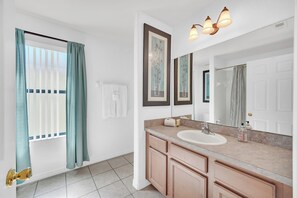 A bathroom with a sink, mirror, and a window with curtains. - 6 miles to WDW: 4 Bedroom/3+ Bath, Private Pool/Hot Tub, Wifi, Game Room, Clean (Kissimmee)