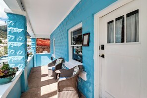 A covered outdoor seating area with wicker furniture and a blue wall. - 'St Ceilia' Apt - Walk to Bisbee Attractions! (Bisbee)