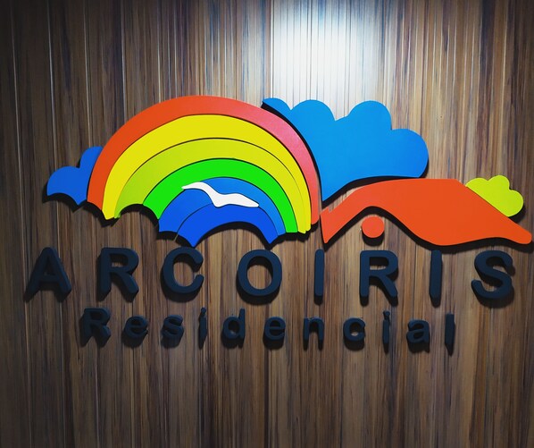 A logo with a rainbow and clouds, and the text "ARCOIRIS Residencial".