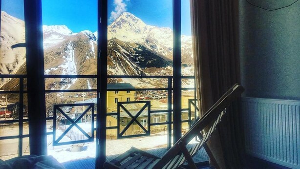 Una stanza con ampie finestre che si affaccia su montagne innevate.