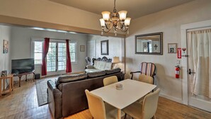 Una sala de estar con un sofá, una mesa de comedor y un televisor.