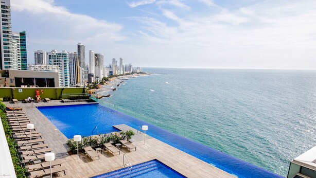 A rooftop pool with a view of the ocean and high-rise buildings. - 1703 Apartamento Luxury en Edificio H2 Condominio (Cartagena)