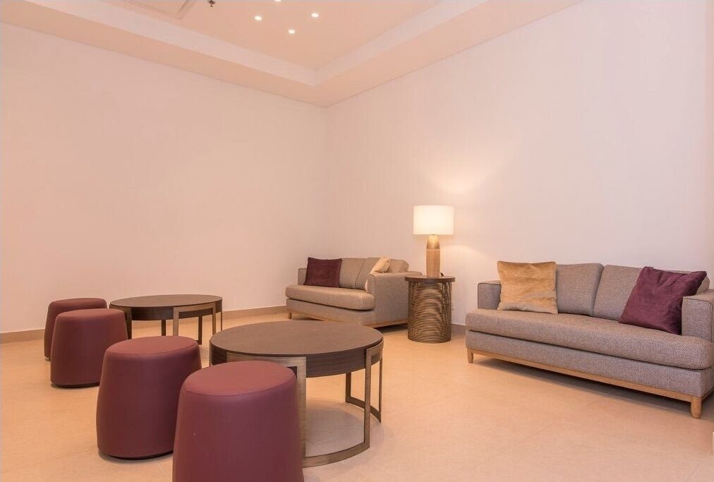 Un salon moderne avec un canapé, deux tables rondes et des poufs.