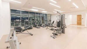 A modern gym with various exercise equipment, large windows, and a clean, bright interior. - 1703 Apartamento Luxury en Edificio H2 Condominio (Cartagena)