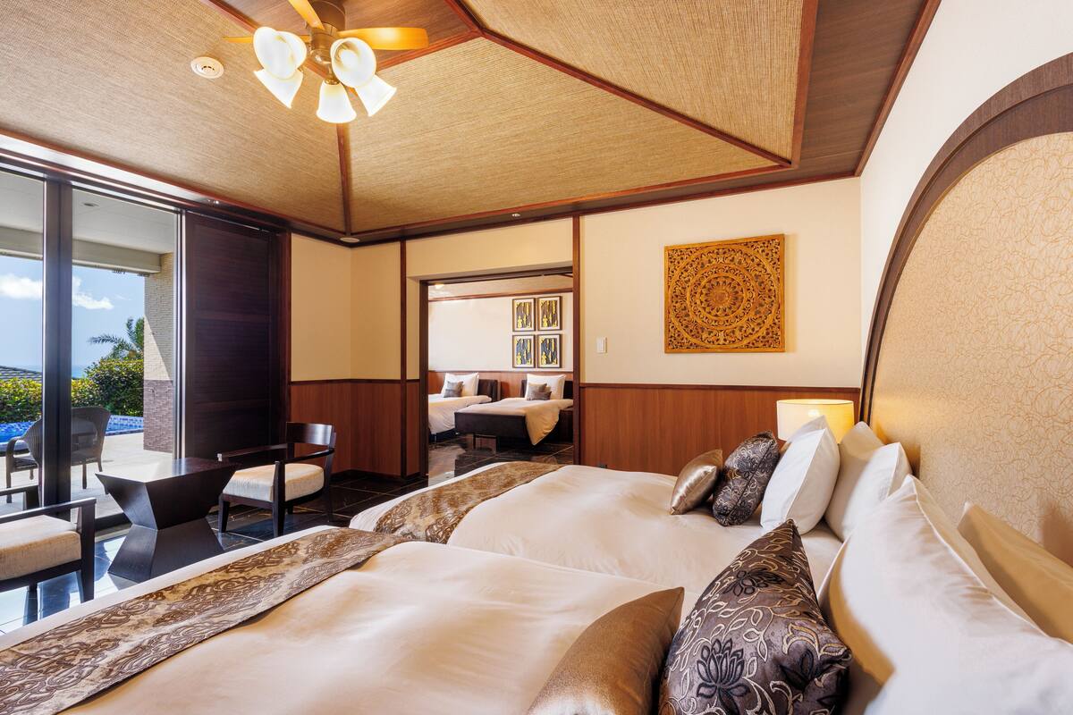 Ein Hotelzimmer mit einem großen Bett, einem Schreibtisch und Blick ins Freie.