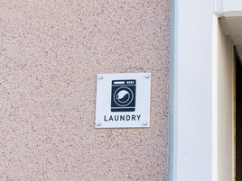 A sign indicating a laundry facility on a textured wall.