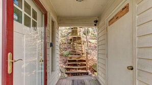 A wooden staircase leading to a porch with a red door and a sign indicating a ski slope. - Relaxing 3 bdrm Mountain Cabin on Wintergreen Resort (Wintergreen Resort)