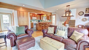 A spacious living room with leather sofas, a wooden coffee table, and a kitchen in the background. - Relaxing 3 bdrm Mountain Cabin on Wintergreen Resort (Wintergreen Resort)