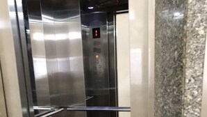 An elevator interior with stainless steel walls, a digital display, and a red floor. - Minh Long Hotel (Da Nang)
