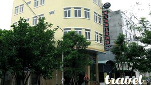 A multi-story hotel with a curved facade, multiple windows, and a sign indicating it is a hotel. - Minh Long Hotel (Da Nang)