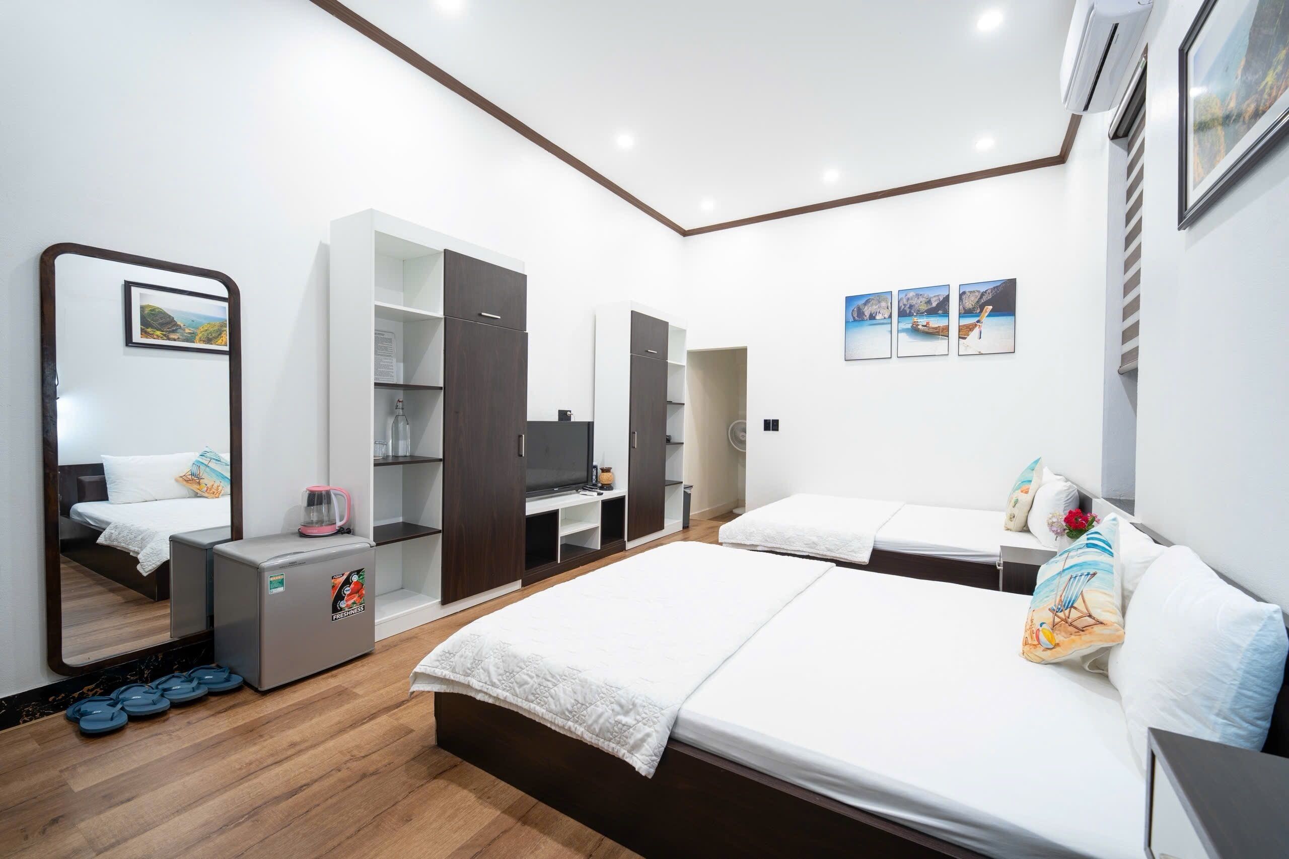 Una habitación de hotel moderna con cama, escritorio, armario y espejo.