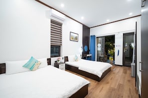 A hotel room with two beds, a window, an air conditioning unit, and a view of the outdoors.