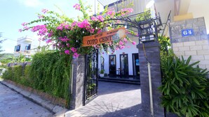 A building entrance with a sign reading "COTO CENTER" and a number "64" on the wall. - Co To Center Homestay (Co To)
