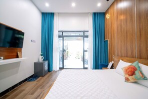 A hotel room with a bed, a television on a wooden shelf, a coffee maker, and a view of the outside. - Co To Center Homestay (Co To)