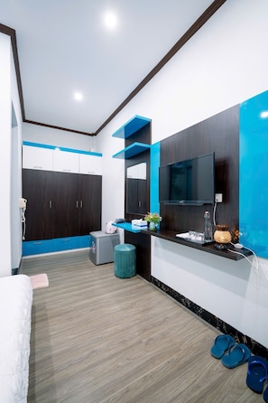 A modern bedroom with a large bed, a TV, a desk, and a wardrobe. - Co To Center Homestay (Co To)