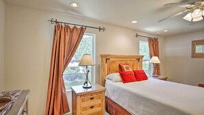 A bedroom with a bed, two bedside tables, a nightstand, a window with curtains, and a ceiling fan. - Cabin w/ Backyard Space - 1/2 Mi to Trinity Lake! (Trinity Center)