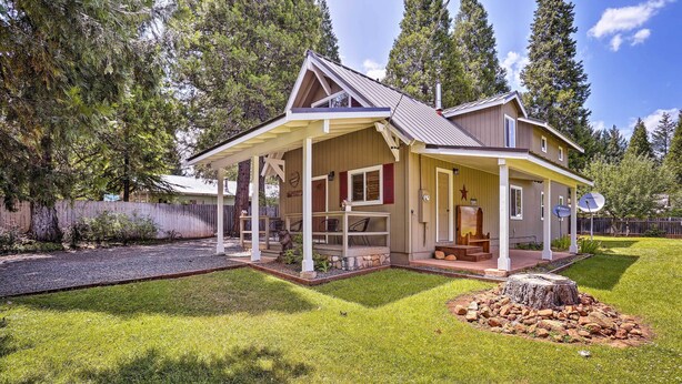 A two-story house with a covered porch, a satellite dish, and a well-maintained lawn. - Cabin w/ Backyard Space - 1/2 Mi to Trinity Lake! (Trinity Center)