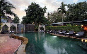 A pool area with lounge chairs, a brick pathway, and a waterfall feature. - Central Privilege Boutique (Siem Reap)