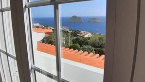 Vista a través de una ventana con cielo despejado e islas distantes.