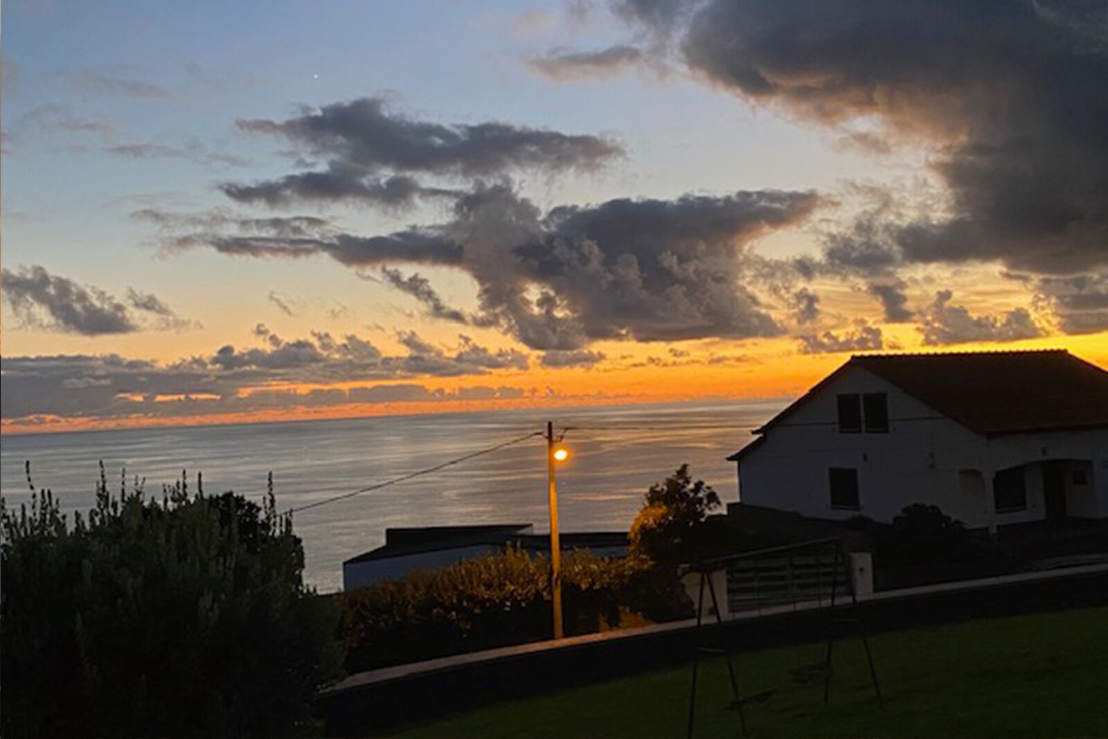 A house with a view of the sunset over the water.