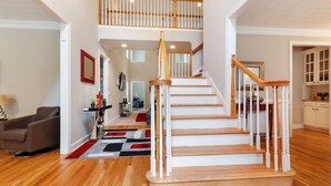 A staircase with wooden steps and white railings leading to a second floor. - Beautiful Atlanta Home Sleeps Up to 20 (Ellenwood)
