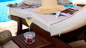 A sun lounger with a straw hat, a glass of white wine, and a magazine on a wooden table by a pool with a view of the ocean. - VILLA LUCE - Five Bedroom Villa, Sleeps 10 (Praiano)