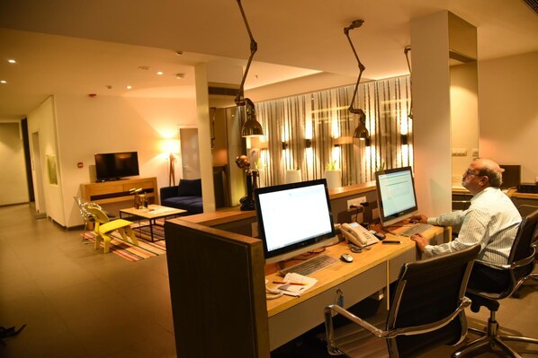 A modern office space with cubicles, computers, and a person working at a desk. - The Port Hotel (Visakhapatnam)
