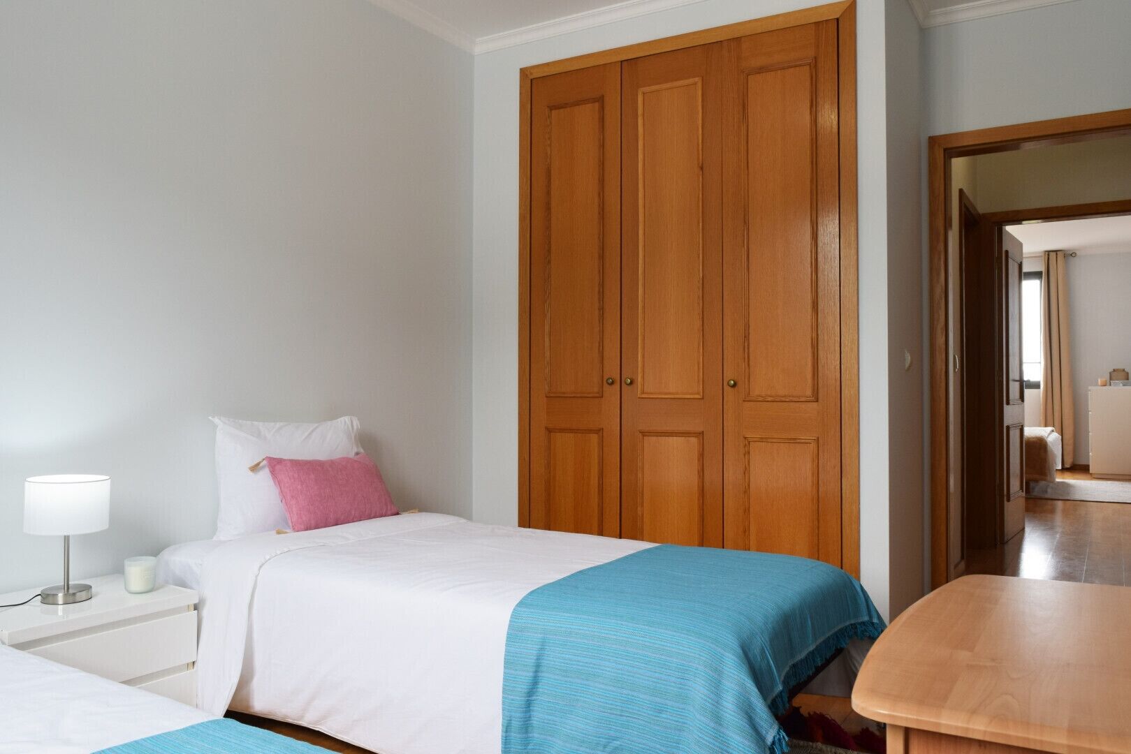 Une chambre à coucher comprenant un lit, une table de chevet, une armoire en bois et une table en bois.