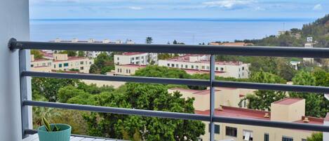 Un balcón con vistas a edificios y al mar.
