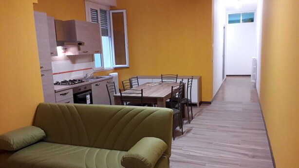A compact living space with a kitchenette, a dining area, and a sofa.