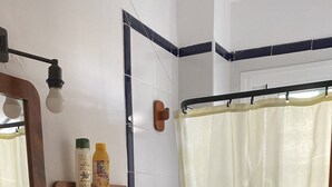 A bathroom with a sink, toilet, and shower curtain. - Rent cozy apartment (Nivar)
