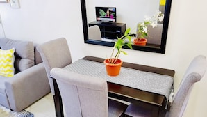 A dining area with a table, chairs, a potted plant, and a television on a wall. - ENTIRE HOUSE/ FULLY AIR CONDITIONED/ HiSpeed Wifi. Cable TV. Smart TV (Pampanga)