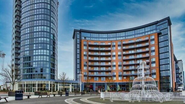 En moderne bygning med en buet facade og et cylindrisk tårn.