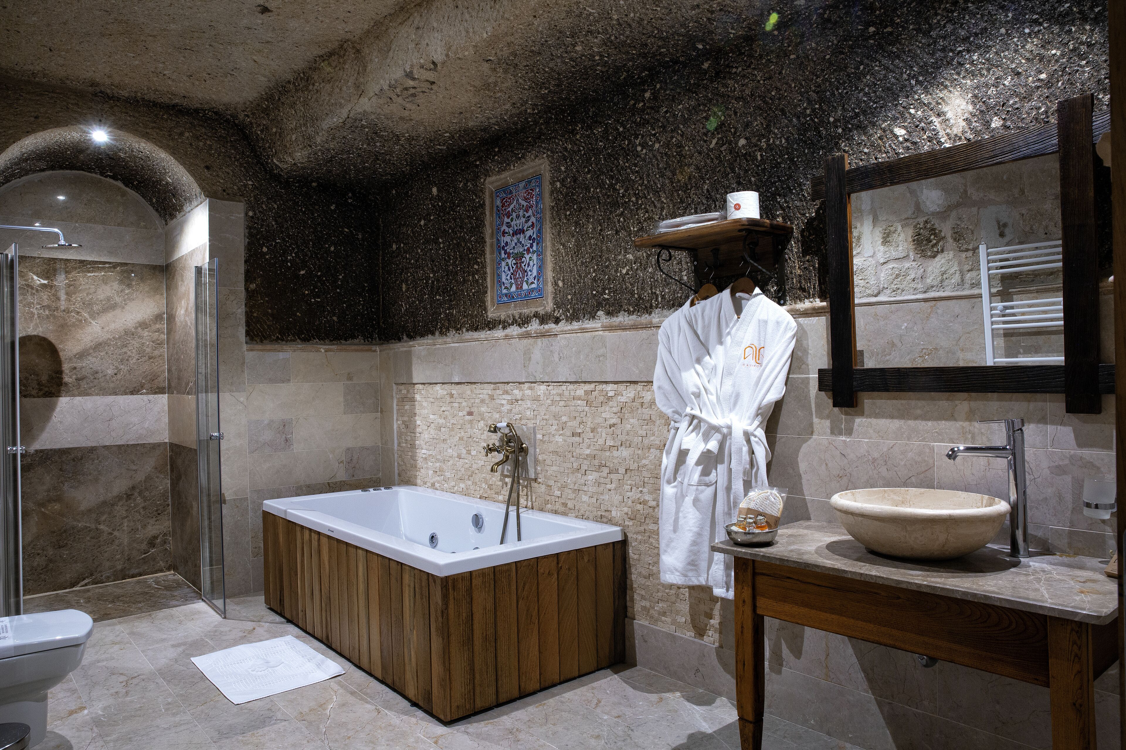 Ein modernes Badezimmer mit freistehender Badewanne, einem großen Spiegel und einem Holzwaschtisch.
