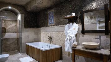 Un baño moderno con una bañera independiente, un espejo grande y un tocador de madera.