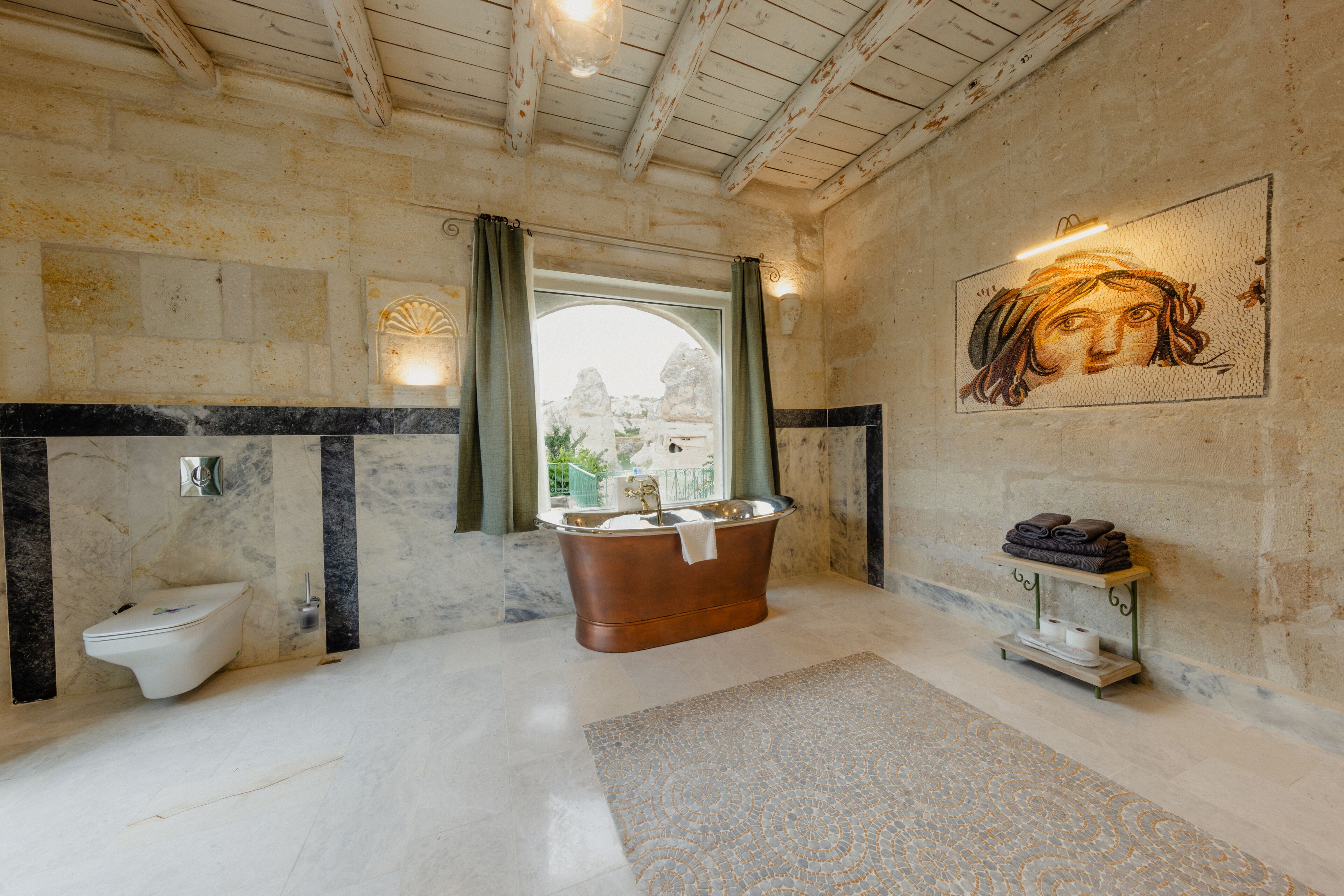 A bathroom with a freestanding bathtub, a toilet, and a vanity with a towel rack.